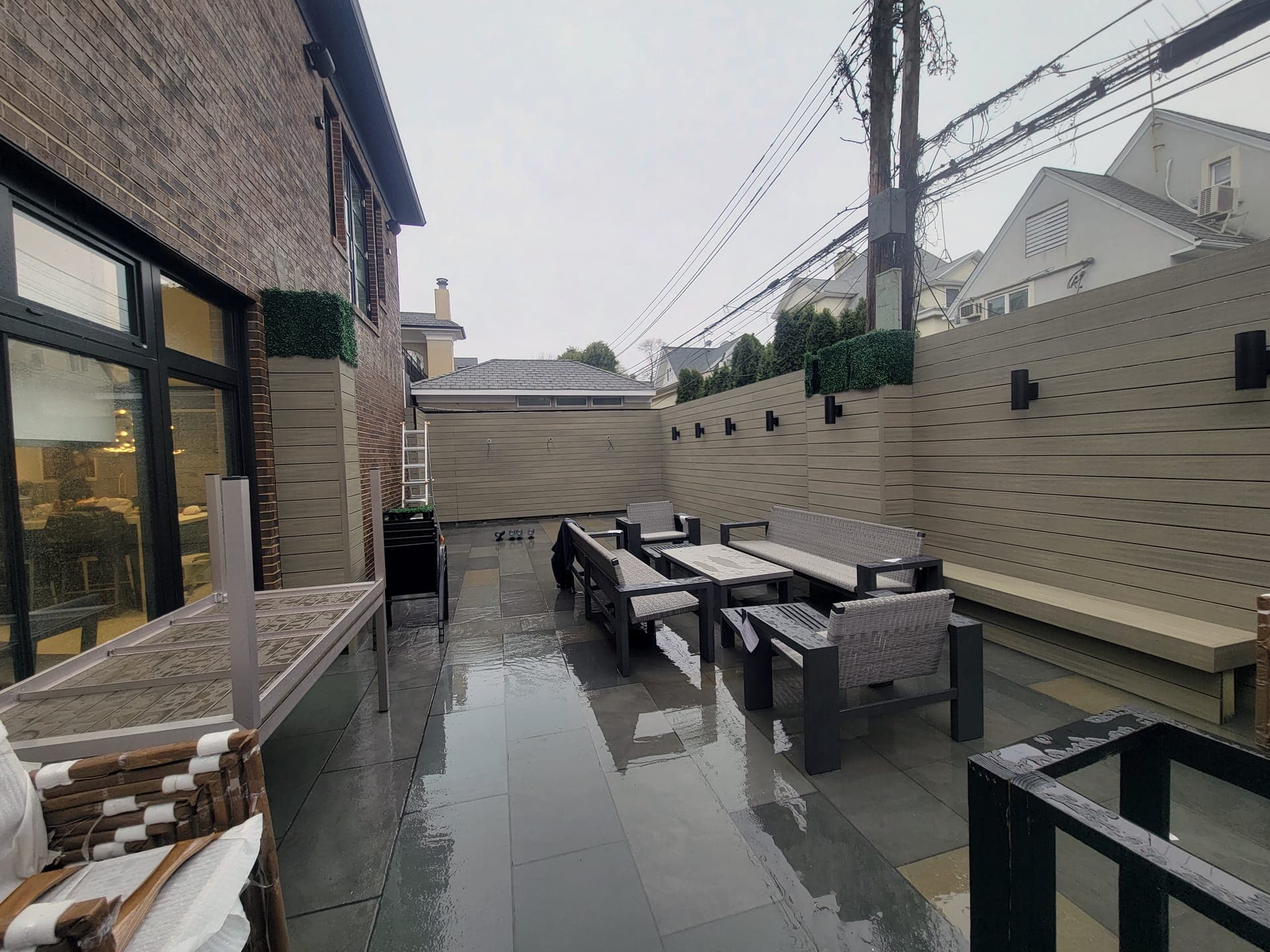 Brick-Walled Backyard — after: Finished patio with wood-slat walls