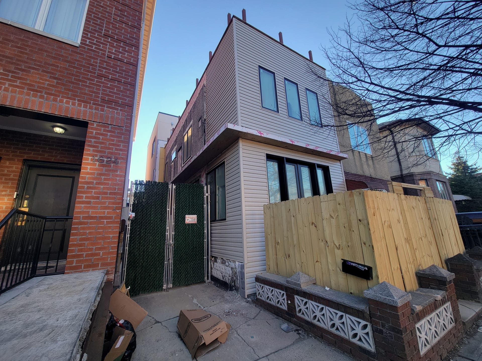East 59th Facade & Pergola — before: Facade mid-construction, raw siding